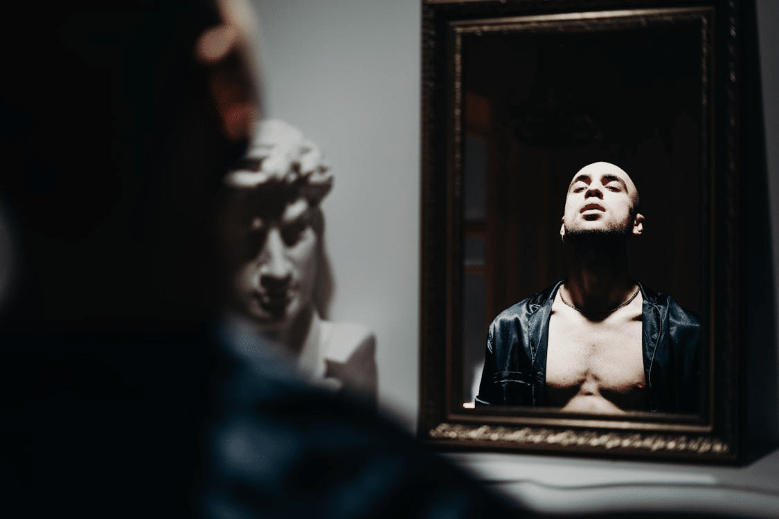 A man looking proudly at the mirror