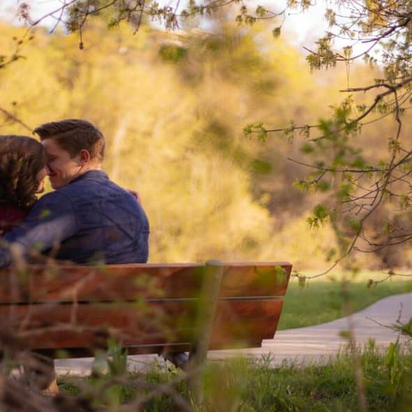 A couple about to kiss on a bench