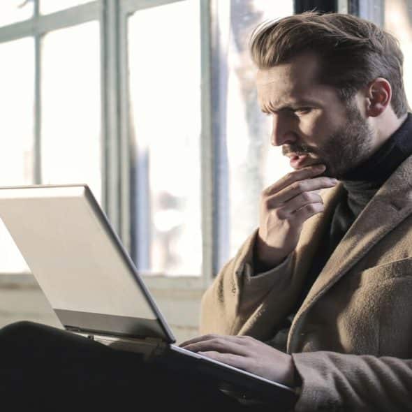 A man thinking in front of his laptop