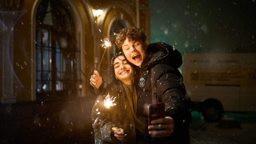 A couple taking a selfie with sparklers.