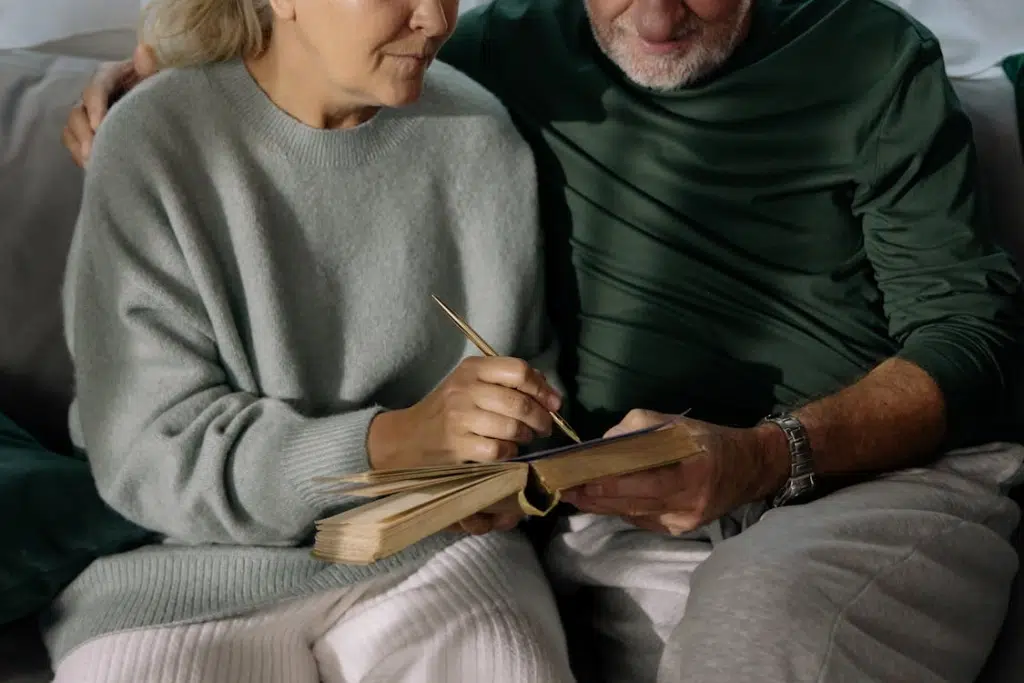 Senior couple sitting down writing on notebook