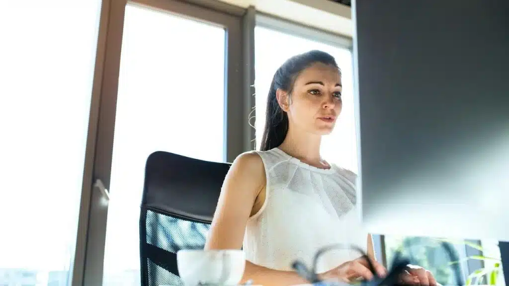 A woman sitting at a desk working on a computer.