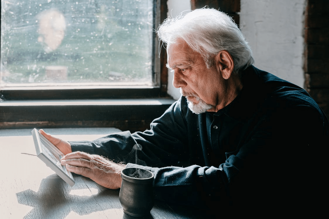 Mature man using tablet sitting down at desk