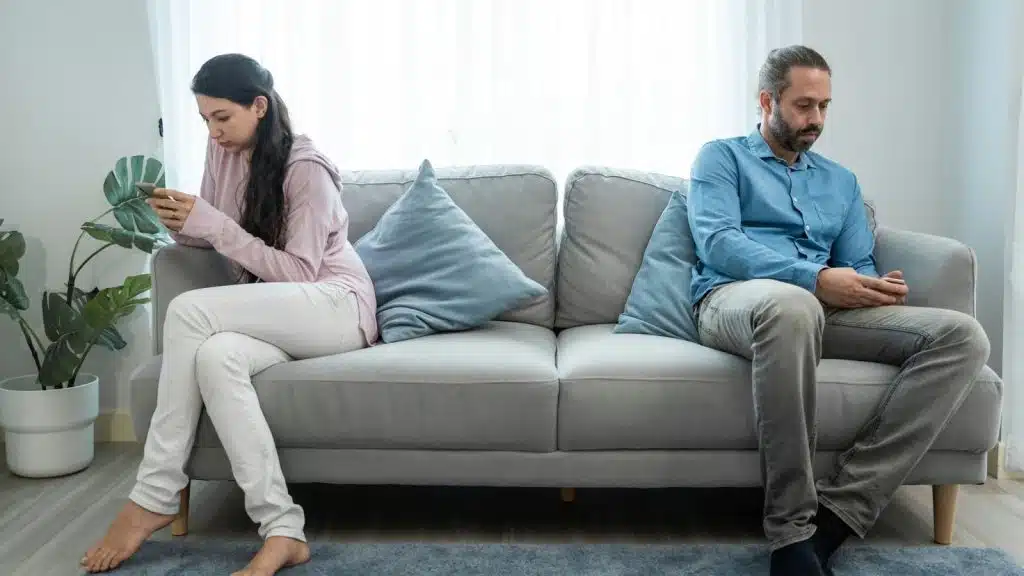 A man and woman busy with their own phone