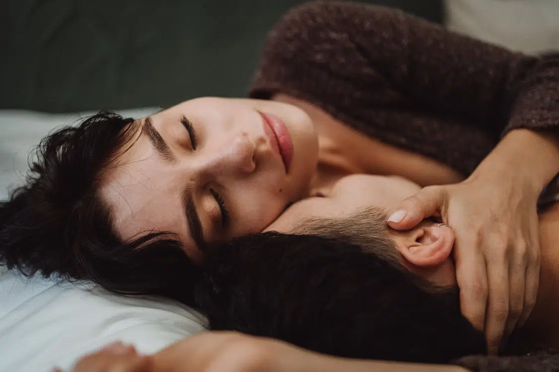 A couple cuddling in bed
