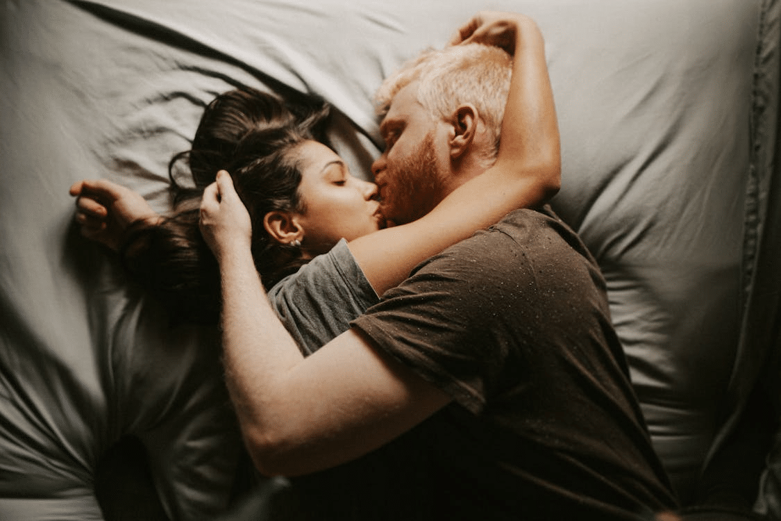 A couple kissing in bed