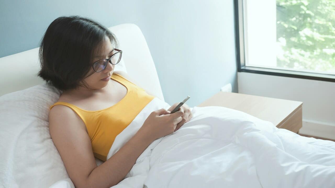 A woman texting in bed