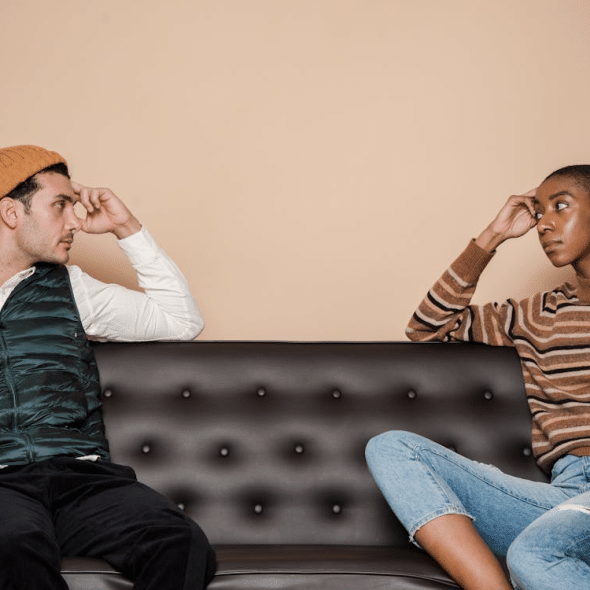 Serious multiethnic couple on couch