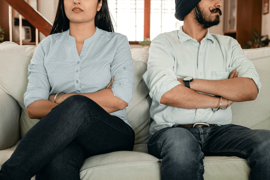 Couple sitting on sofa having marriage issues