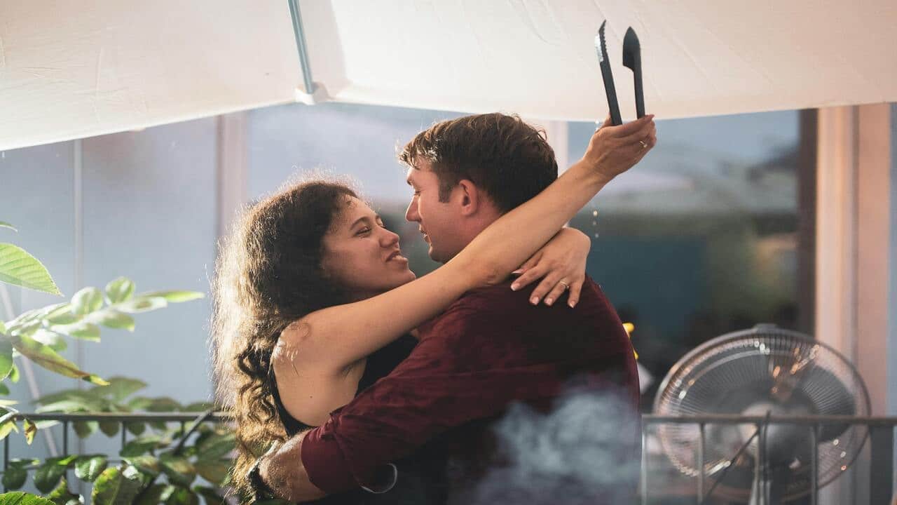 A couple hugging during a barbecue party