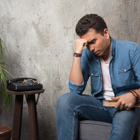 Thoughtful man sitting on chair with book