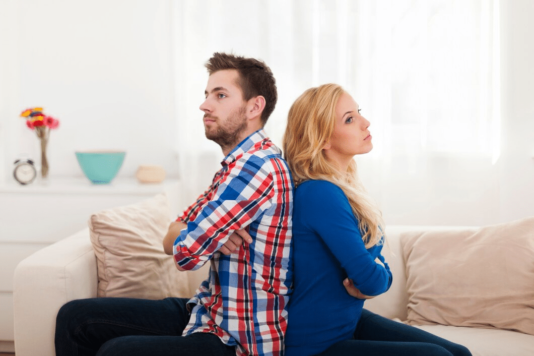 Young couple sitting back to back