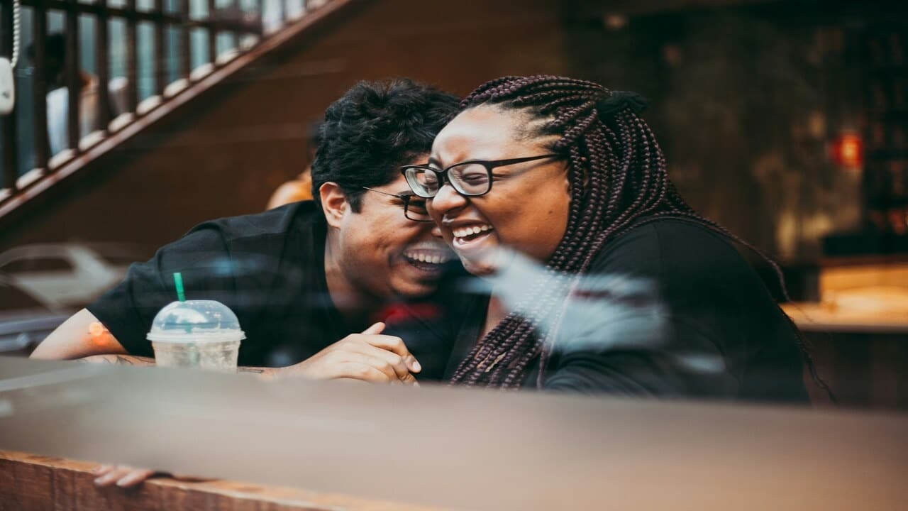 A couple laughing at a coffee shop