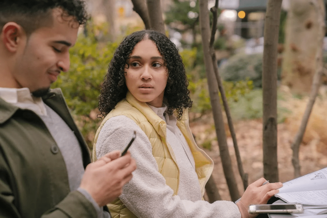 Couple at table with textbooks with smartphones