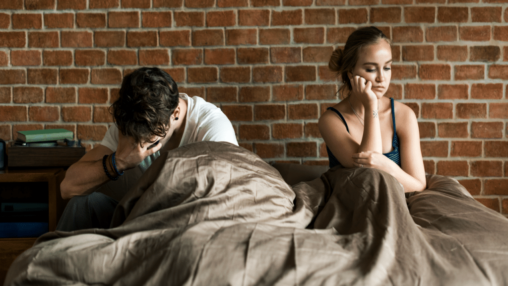 A couple looking sad in the bedroom