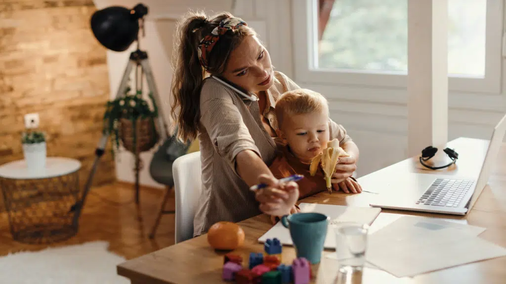 A mom working while feeding her son