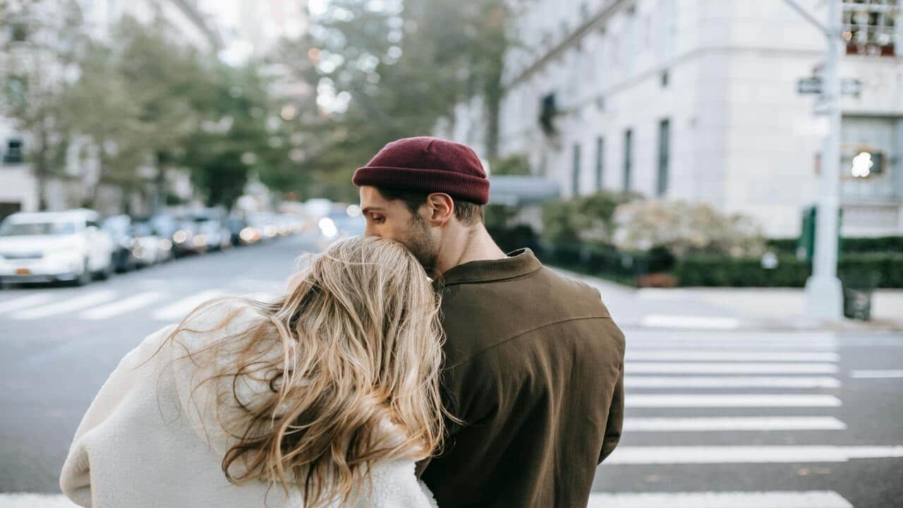 A man giving his wife a forehead kiss