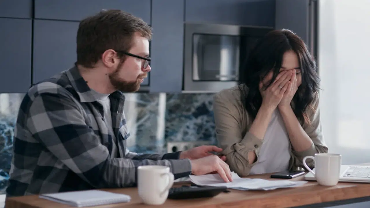 A couple looking stressed at their bills