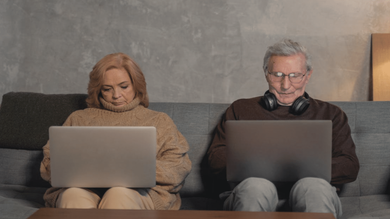 A mature couple busy with their laptops