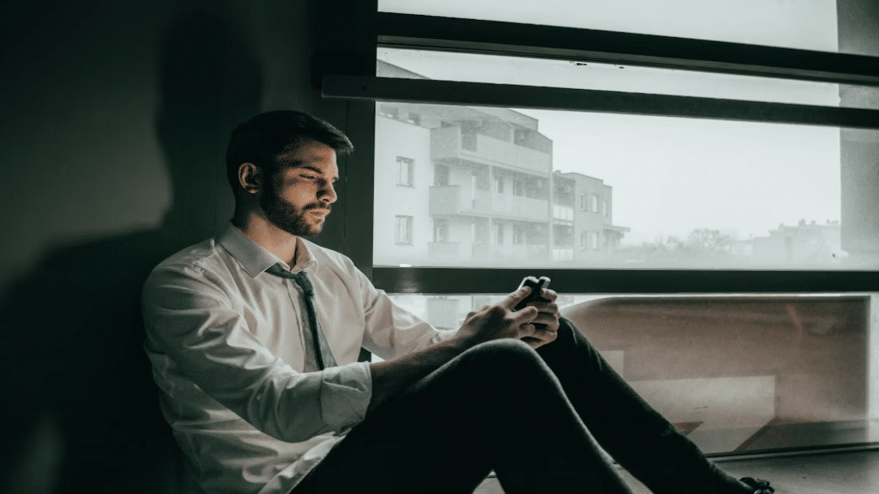 A man looking sad while using his phone
