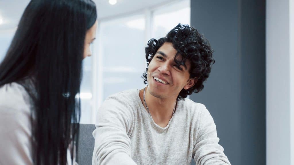 A smiling woman looking at a woman.