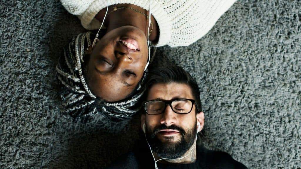 A man and woman listening to a music