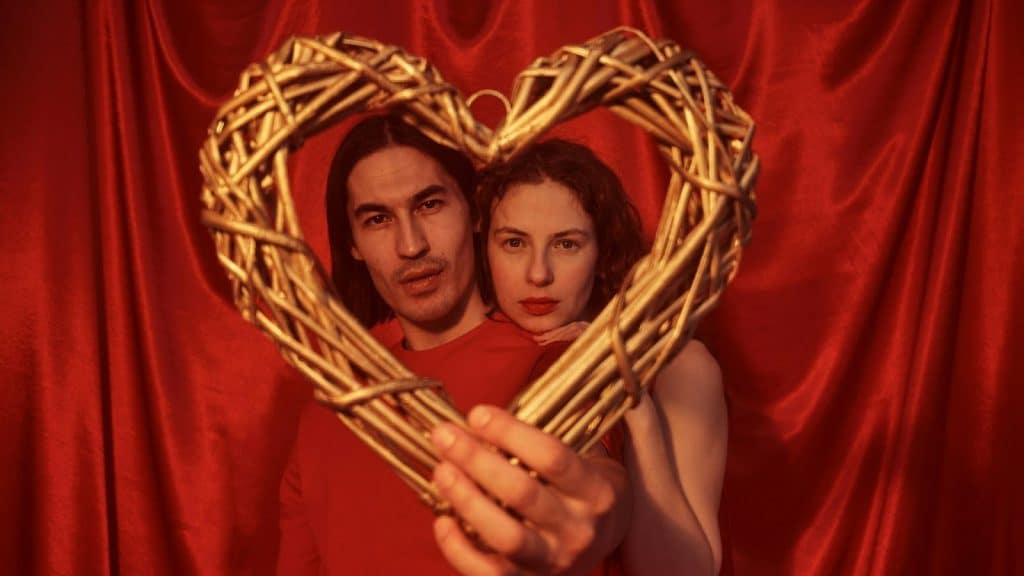 A man and woman holding a heart-shaped wood 