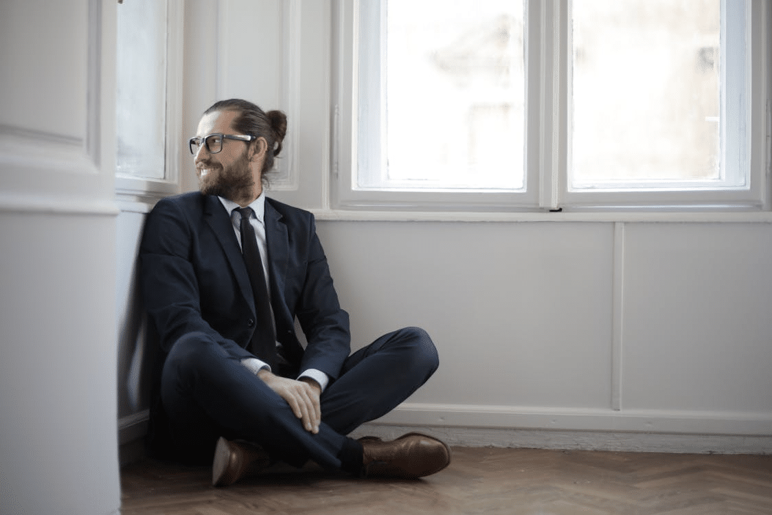A man smiling while sitting on the floor