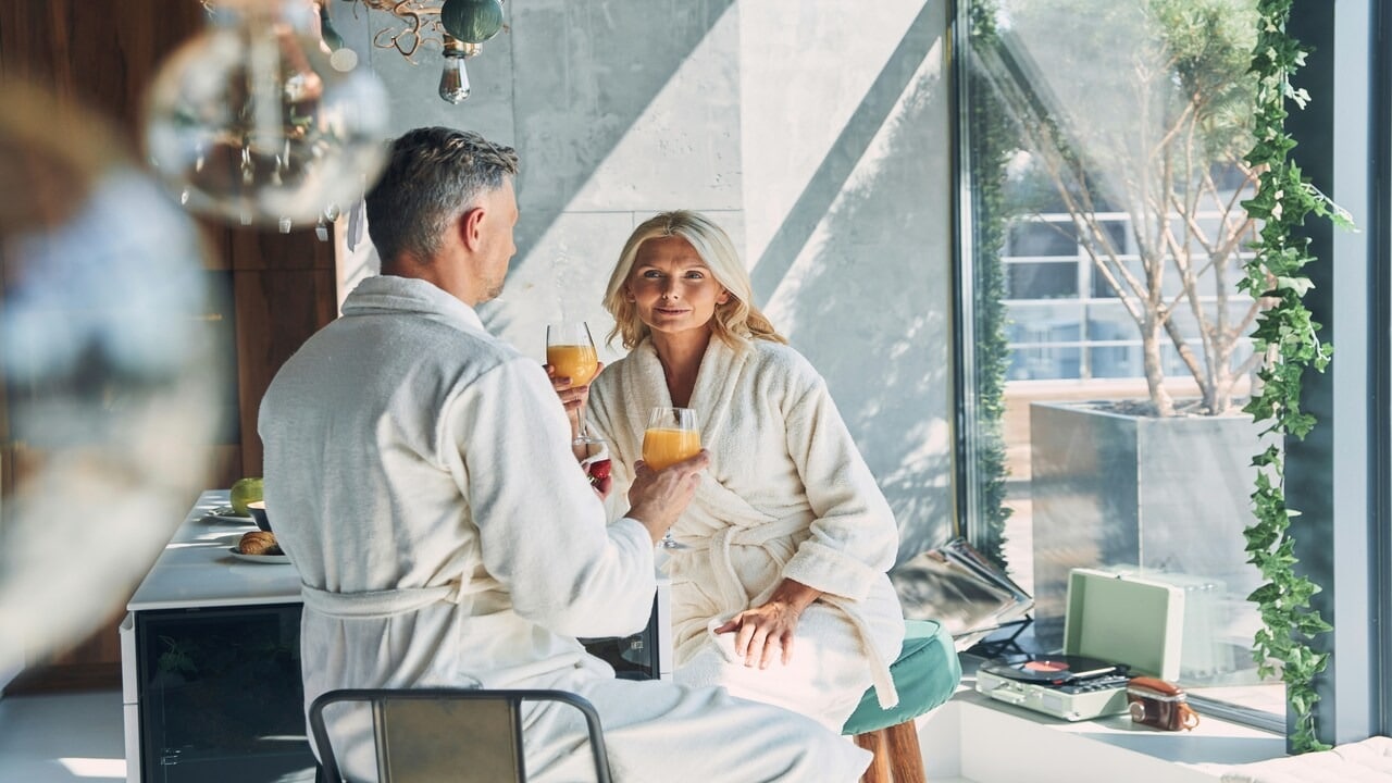 A mature couple talking over mimosas