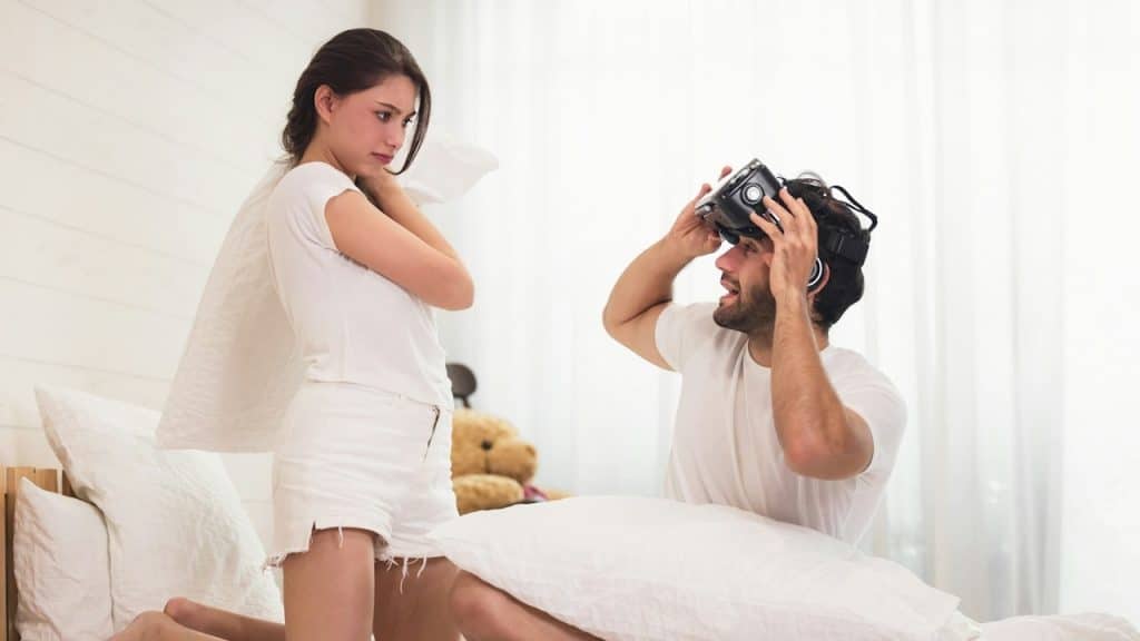 Woman fighting with her husband man with short dark hair and using his vr head set gaming video with the 3d glasses.