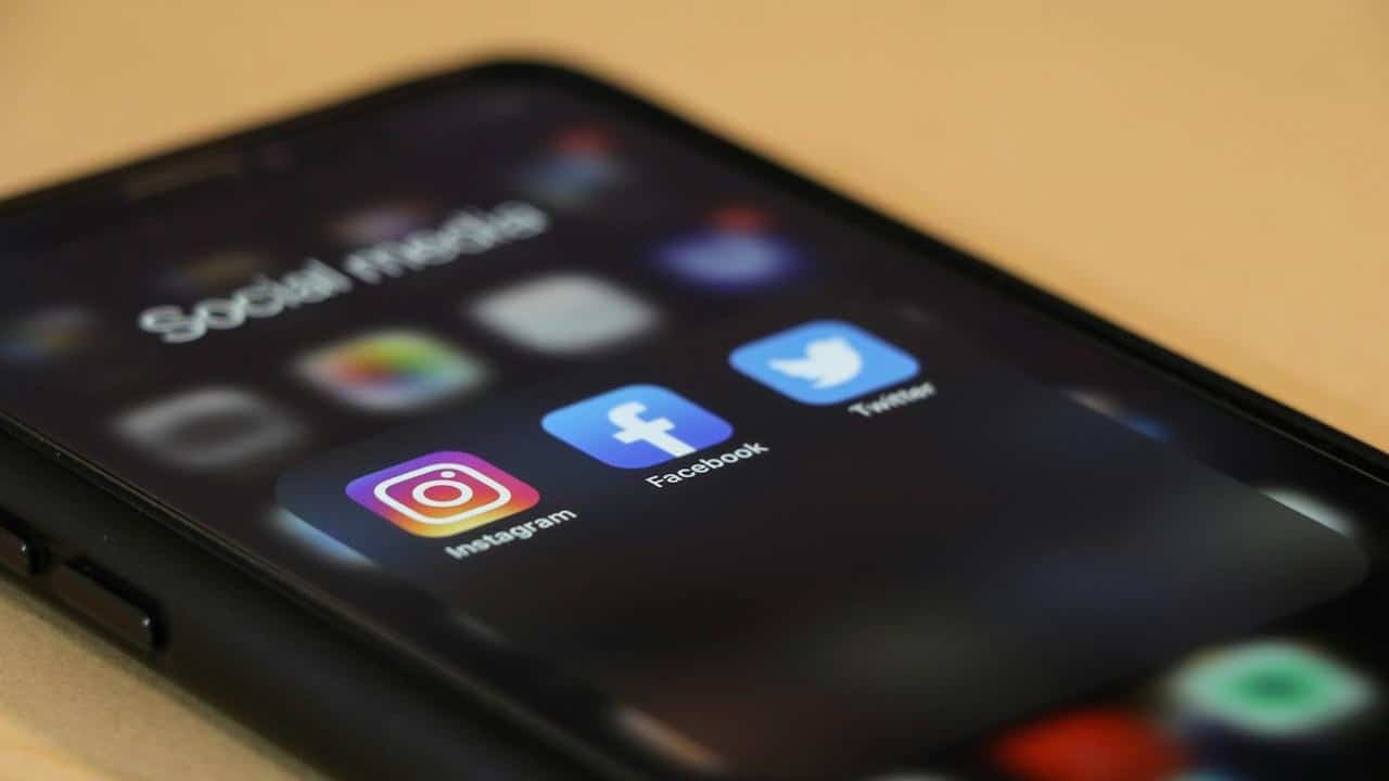 The screen of a mobile phone displaying a folder containing social networking app icons.
