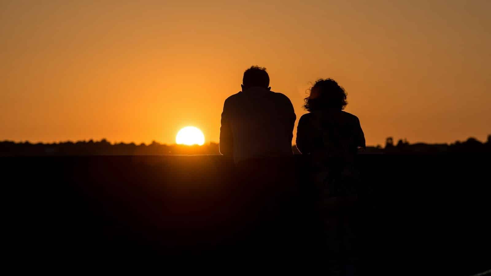 A man and woman watching sunset together