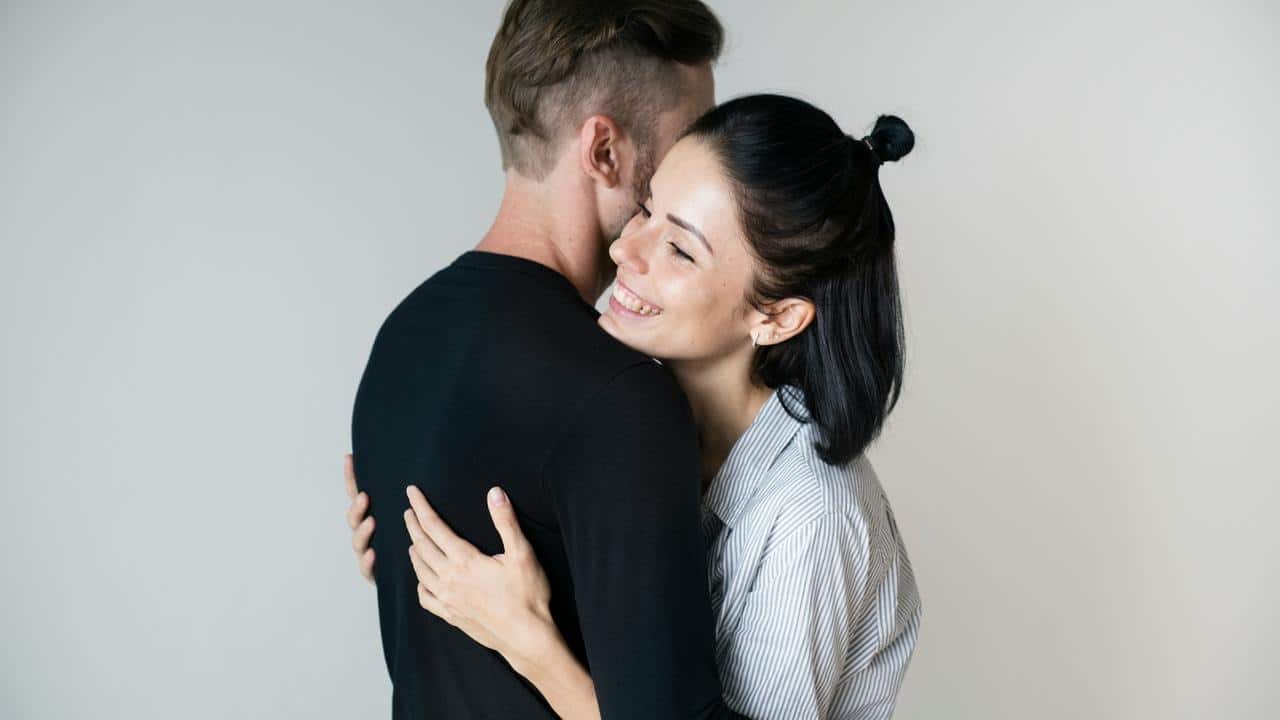 A smiling couple hugging closely