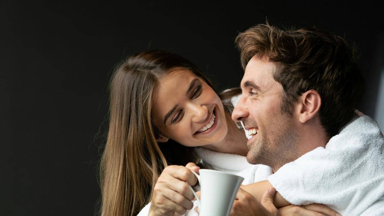 A smiling couple in white robes