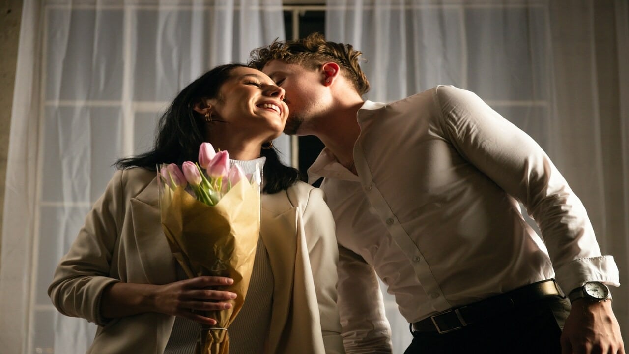 A man giving his wife a bouquet of flowers