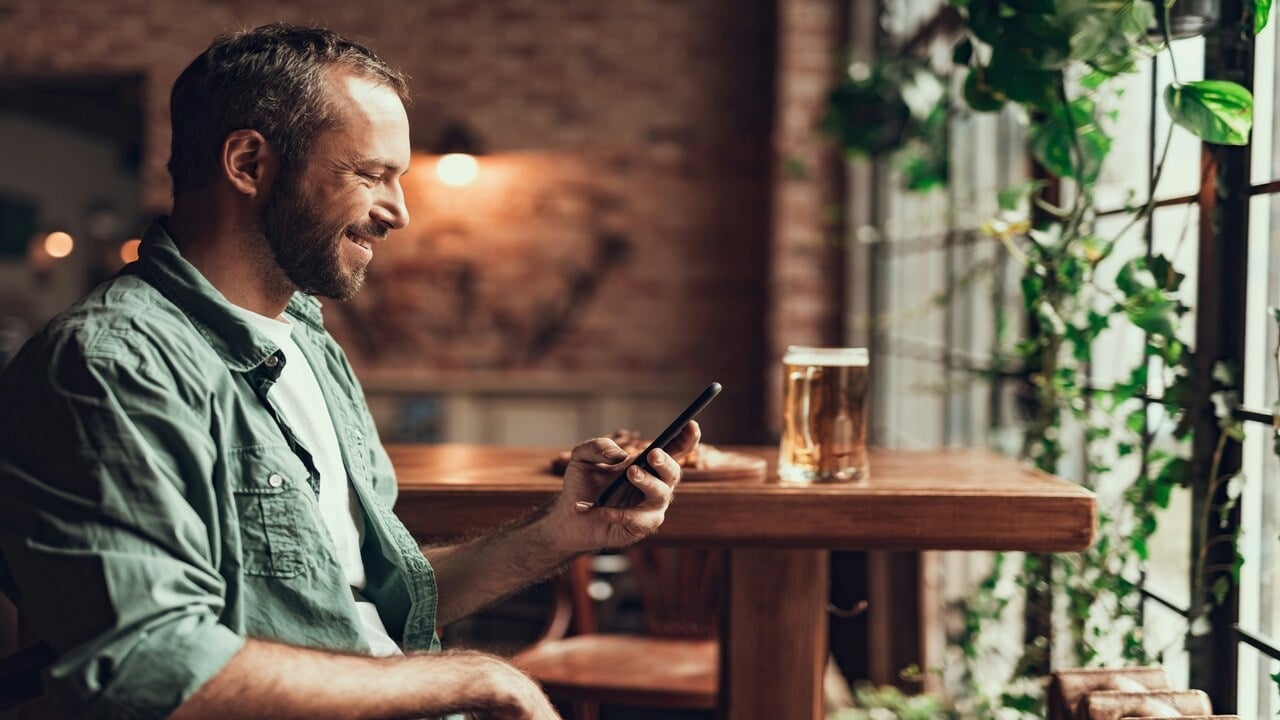 A man smiling while texting