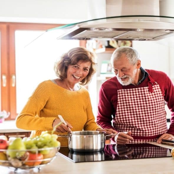 An older couple cooking together