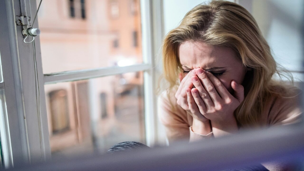 A woman crying by the window