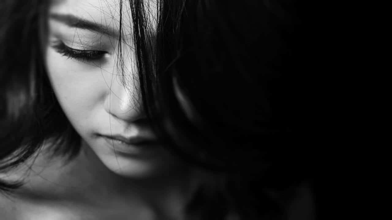 A grayscale photo of a sad woman