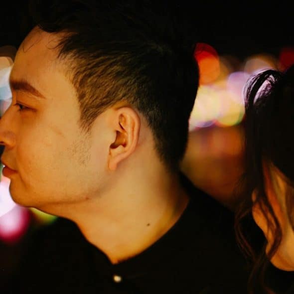 A man looking to the side as a woman stares at him.