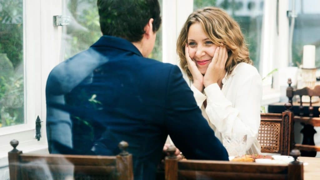 A woman smiling warmly at a man