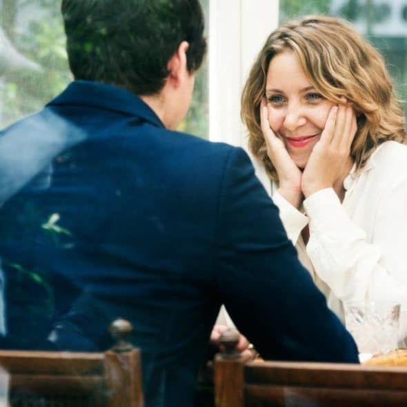 A woman smiling warmly at a man