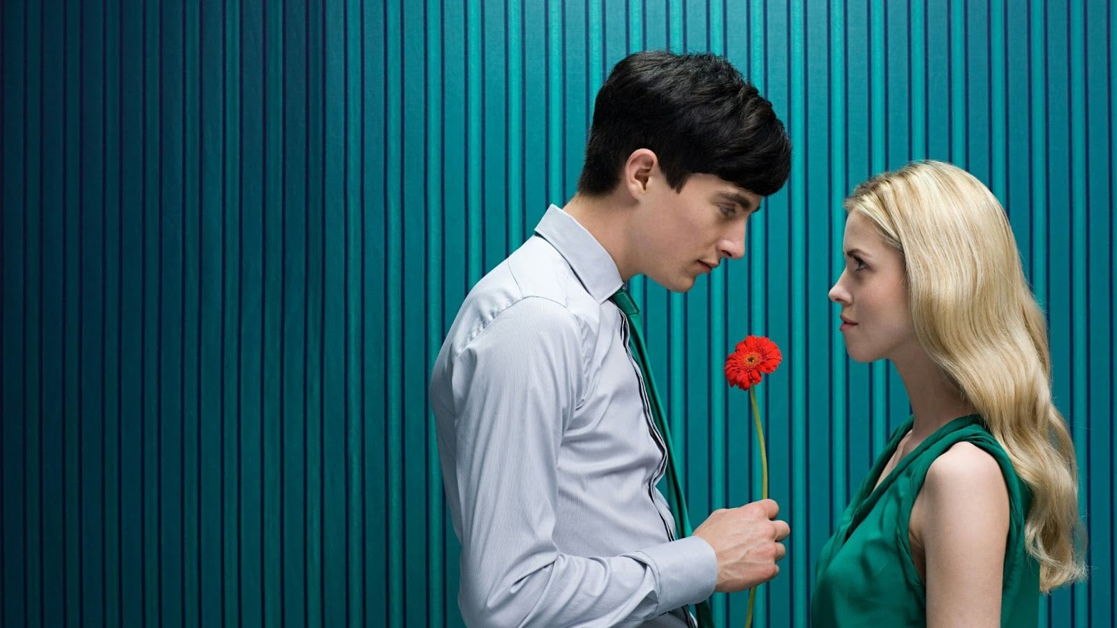 A man holding a flower for woman