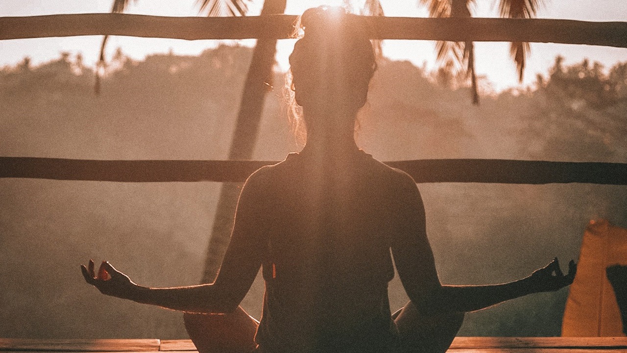 Silhouette of a woman meditating.