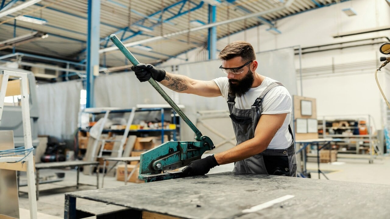 A mechanic cutting a metal part