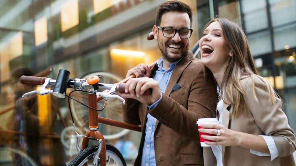 A man and a woman riding a bicycle.