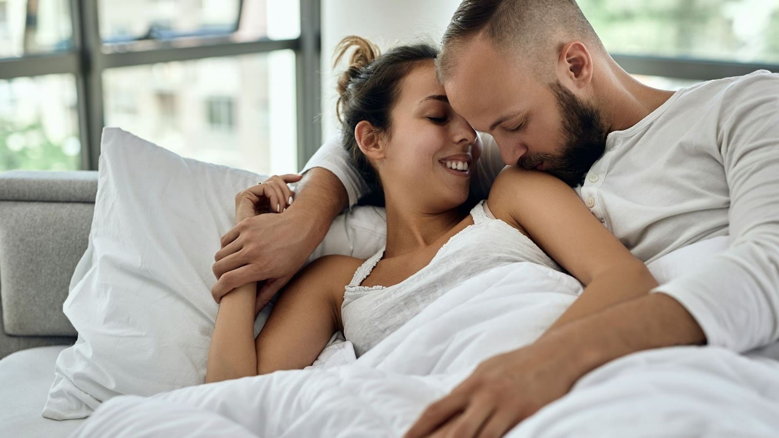 A man kissing woman’s shoulder