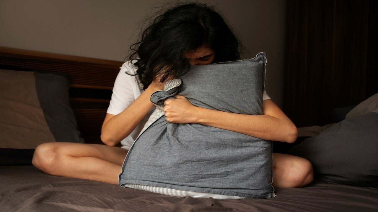 A woman panicking in bed