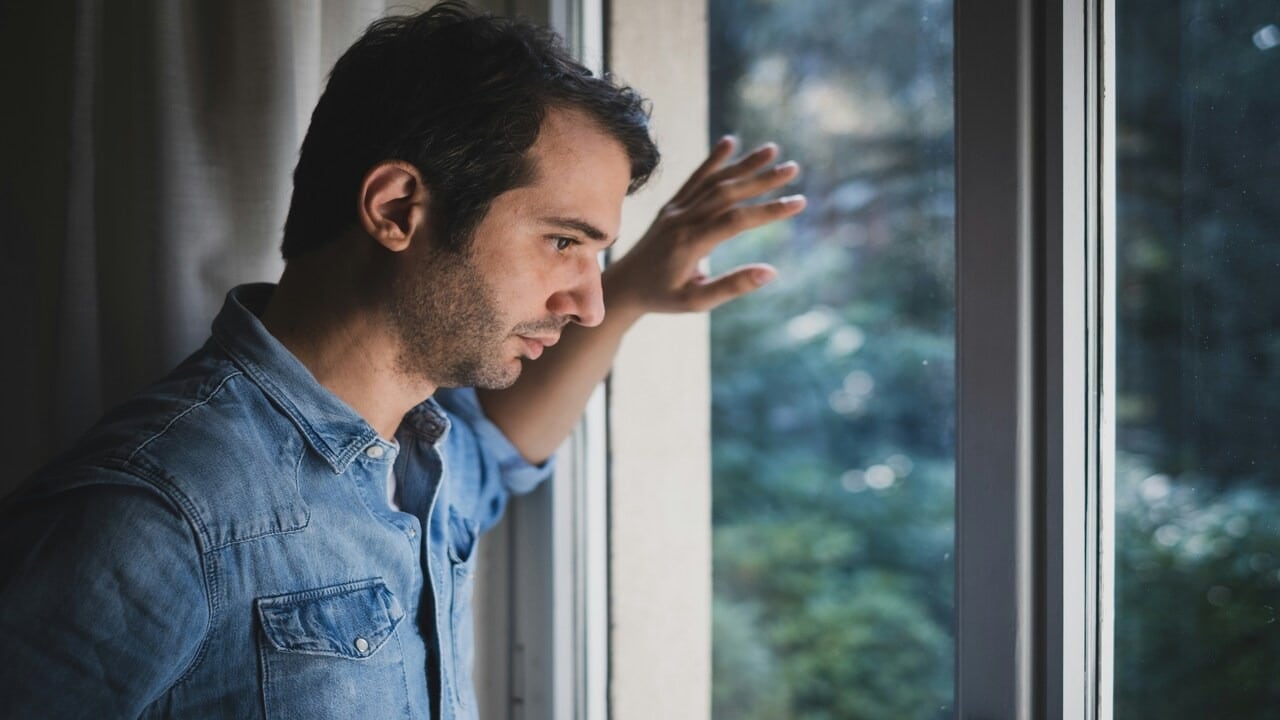 A sad man looking out the window