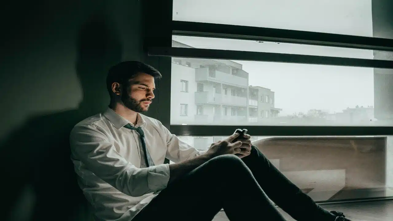 A sad man looking at his phone